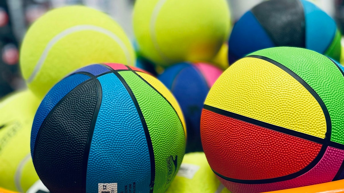 Sports balls and equipment on shelves for buying research.