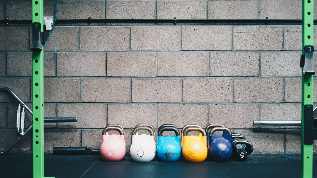 Basketballs stored on a rack in a gym.