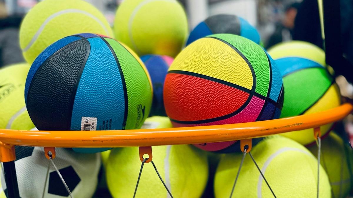 Sports balls and gear arranged on an equipment bench.