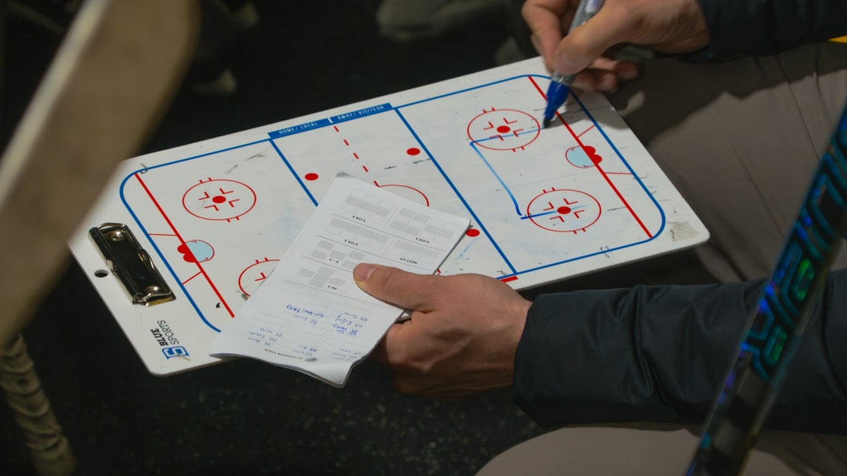 Coach reviewing a play diagram and team checklist.